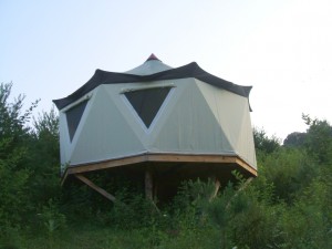 Dramatic view from down slope of a grand yurt style Yome home tent structure