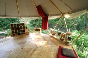 Stunning interior view of a living tent Yome yurt home with shelving and craft objects displayed