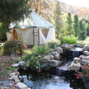 Tiny home yurt dwelling by a waterfall in forest