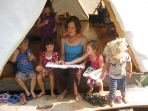 Woman teaching a group of small children in a portable tent home Yome like a yurt but stronger and more affordable